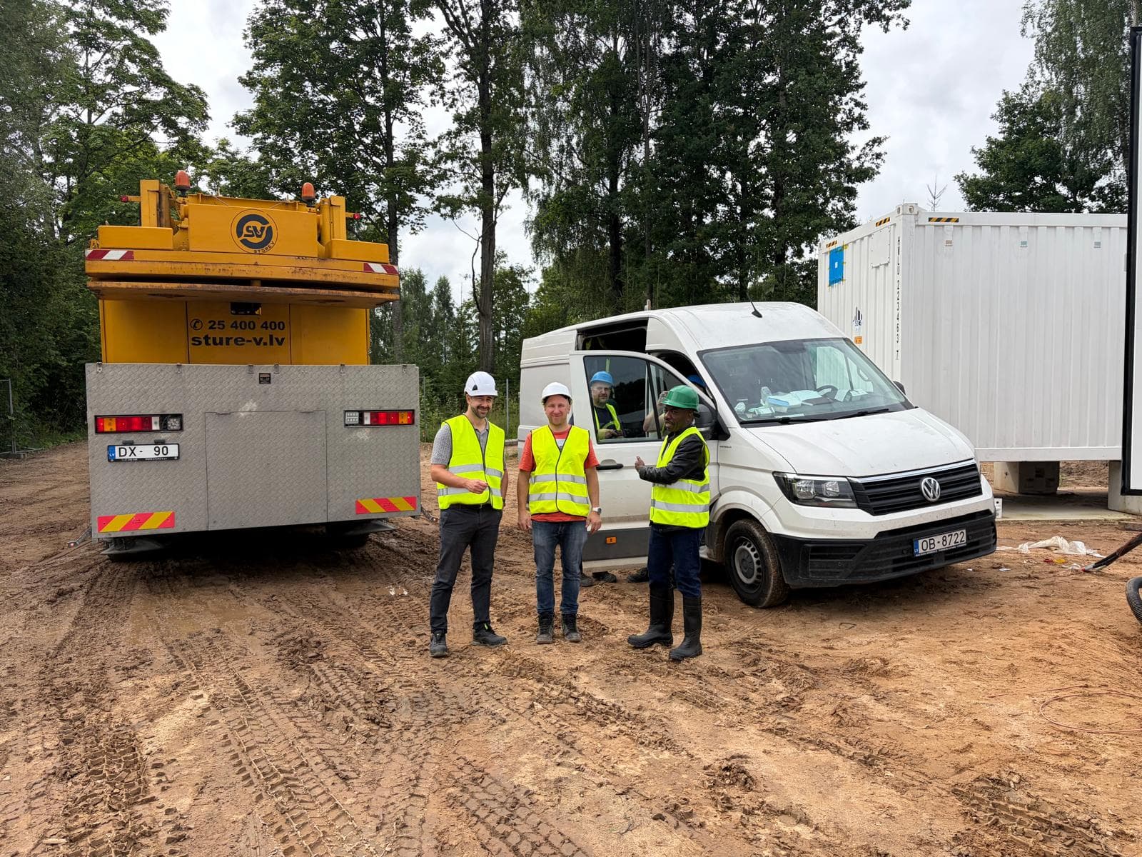 AIDG leadership reviewing containerized BESS battery storage units at an operating solar facility
